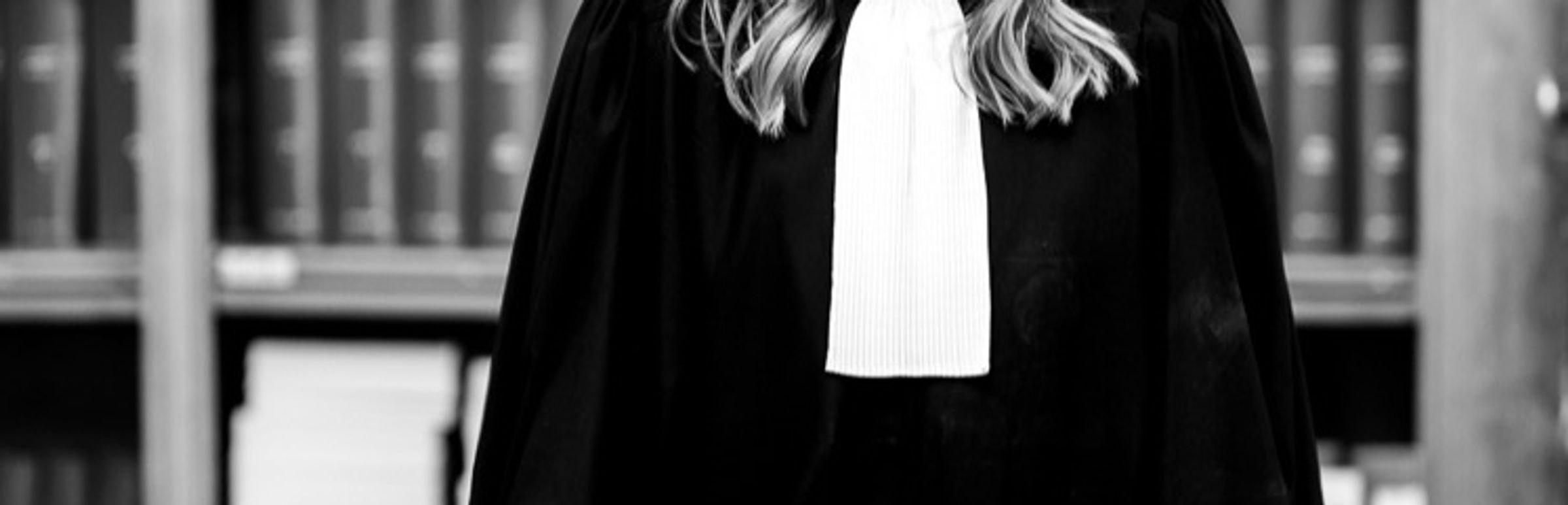 Maître Mélanie Laporte en robe d'avocat devant une bibliothèque juridique